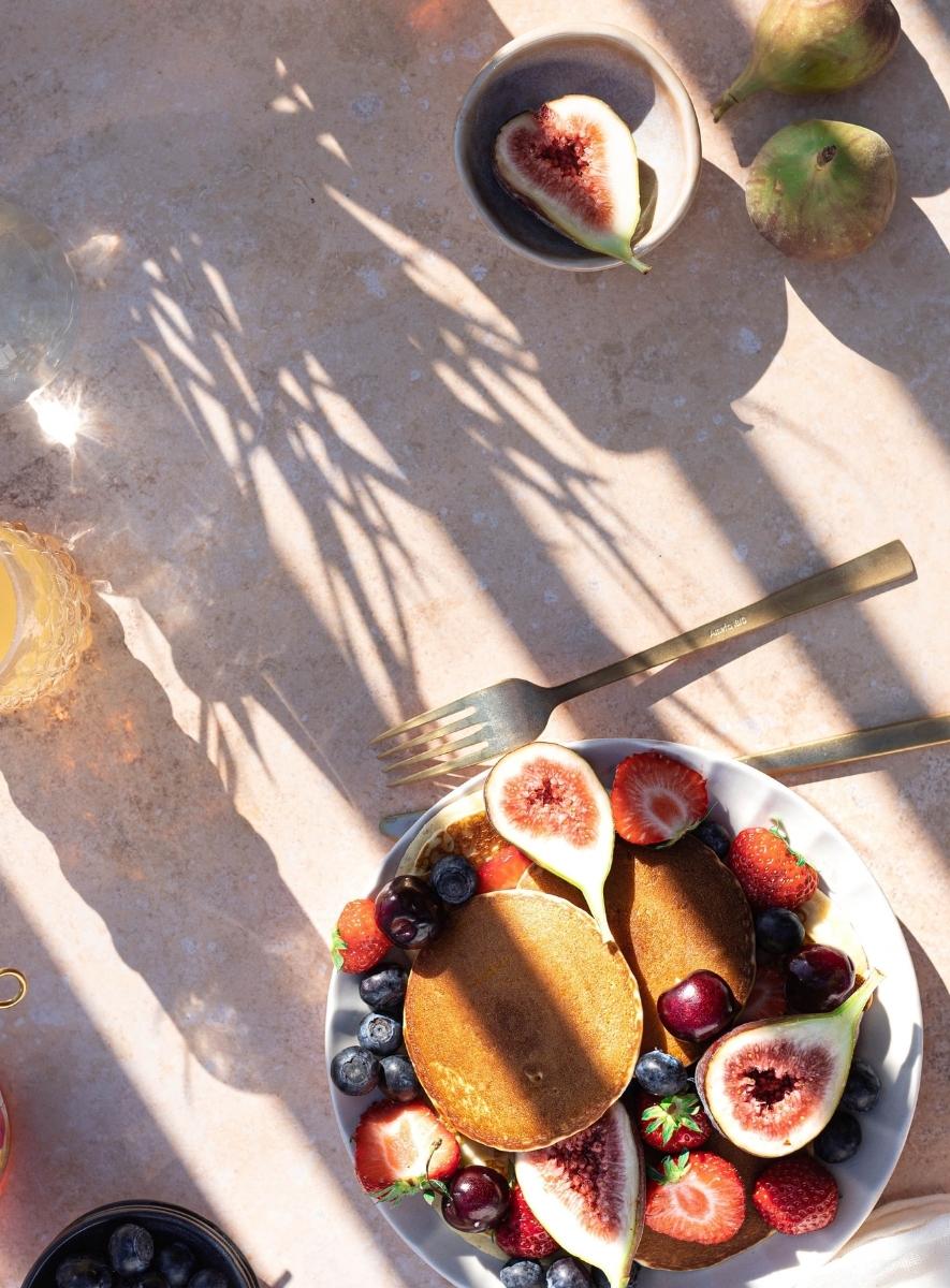 Healthy breakfast bowl of fresh fruit, including figs, blueberries, strawberries, cherries and papaya.